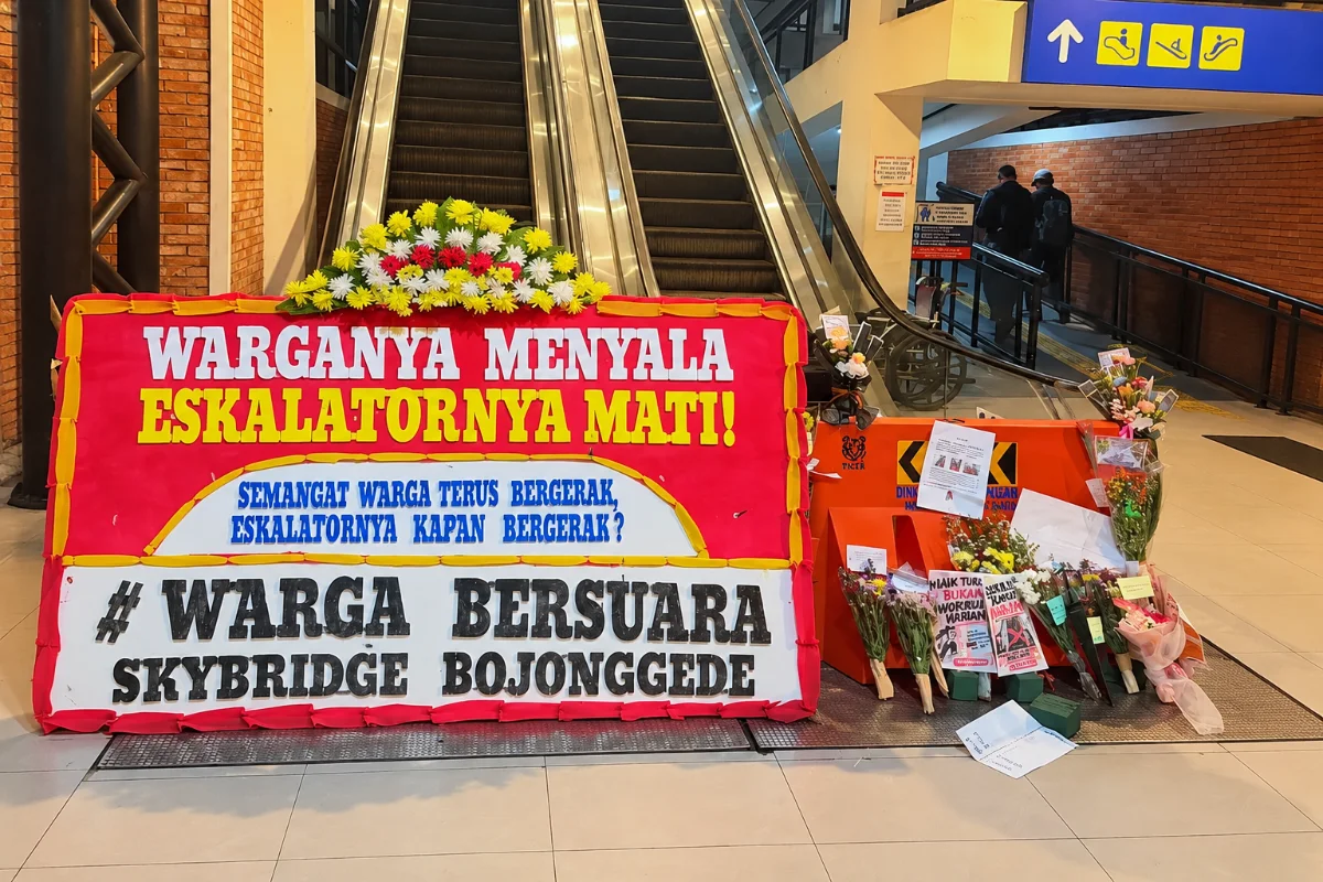 Karangan bunga protes di dekat eskalator Skybridge Stasiun Bojonggede yang tidak berfungsi