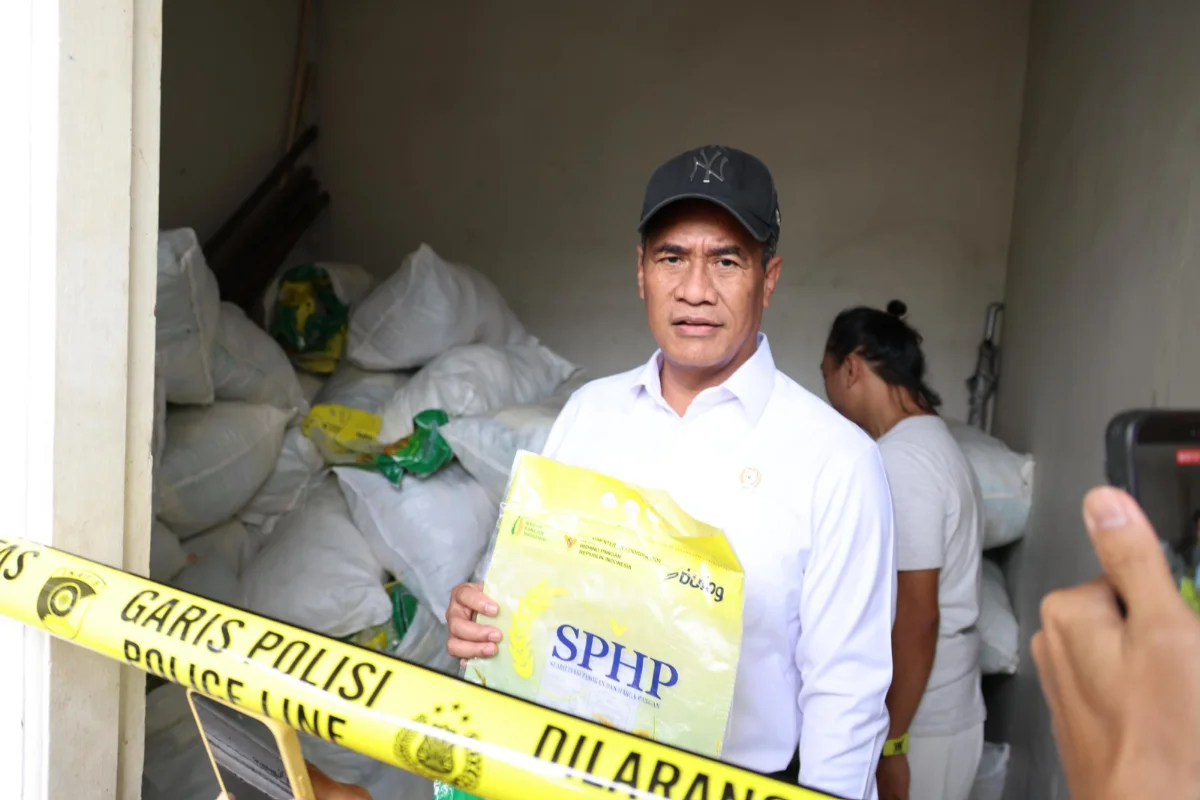 Menteri Pertanian Andi Amran Sulaiman menunjukkan kemasan beras SPHP di lokasi dugaan pengoplosan beras bersubsidi yang dipasangi garis polisi.